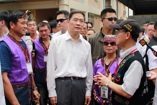 张志军在小林社区参访,认真听取村民对社区情况的介绍