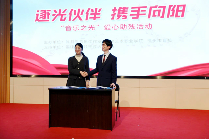 签约仪式，陈君恩老师与福建艺术职业学院代表握手 图片来源：福州盲校.jpg