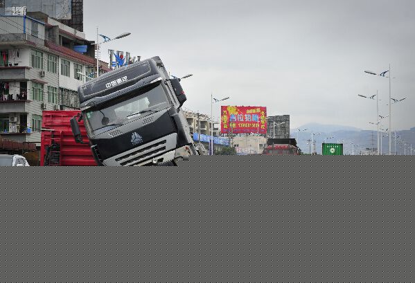 半挂车“骑”上隔离栏　车厢侧翻石头撒一地(图)